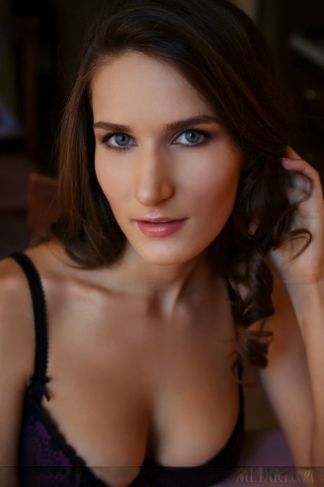 Solo model with great legs slips off black bra and panty set to pose nude