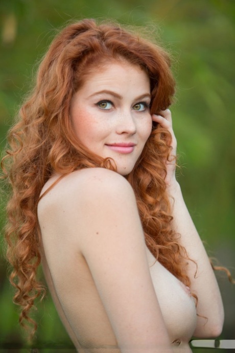 Sexy redhead Heidi Romanova takes off her bikini for nude poses in nature