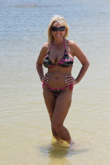 Blonde amateur dildos her vagina while on a scrubby beach