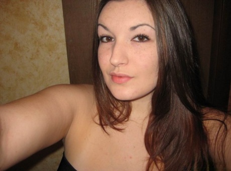 Curvy girl takes self shots in a mirror while wearing an off shoulder dress