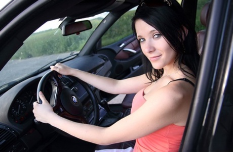 Pretty brunette uncovers her big boobs while driving a vehicle