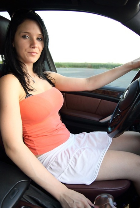 Pretty brunette uncovers her big boobs while driving a vehicle