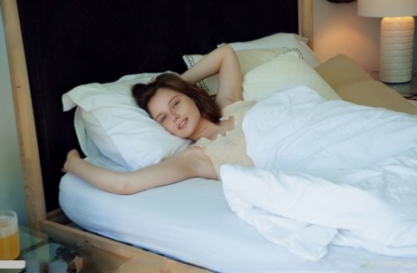 Young redhead Sienna wakes up before showing her bald pussy on her bed