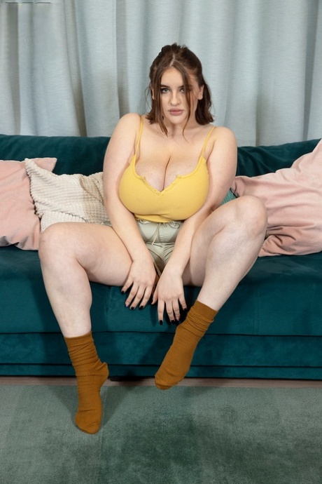 Solo girl Molly Evans pulls out her massive boobs upon a sofa
