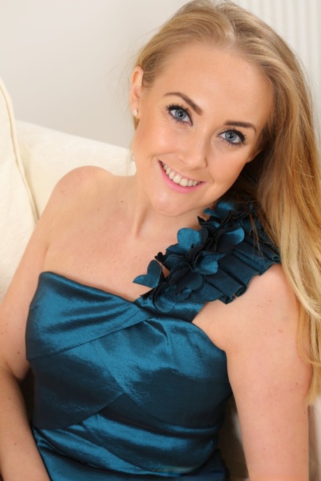 Czech mom Lucy Anne smiles while posing in hot sheer pantyhose on the sofa
