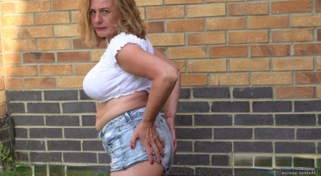 Old granny with big tits strips nude & stretches her muff with a toy outdoors