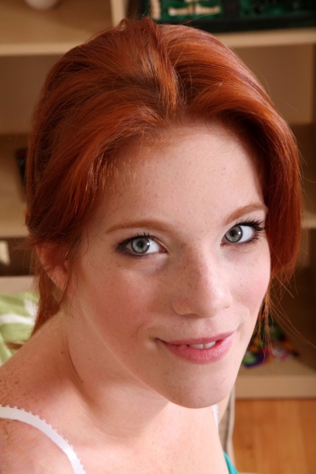 Attractive redhead with freckles Roxy Rush reveals her body on a couch