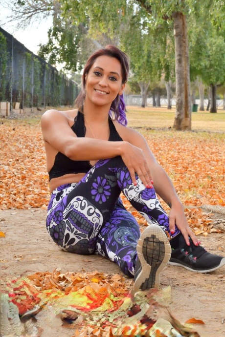 Amateur MILF Mia unveils her small tits & plays in fallen leaves in yoga pants