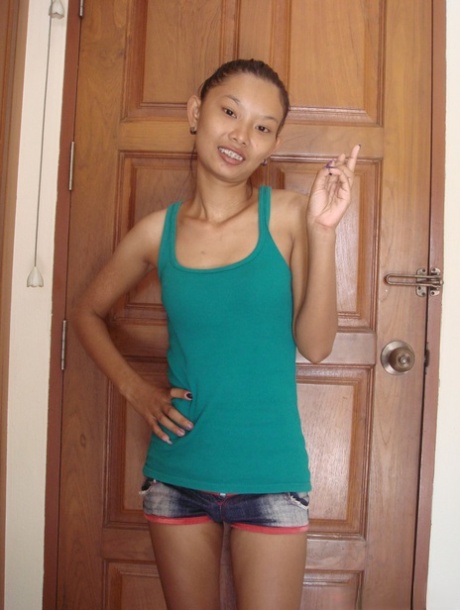 Skinny Asian babe Tik unveils her tiny tits and her shaved pussy