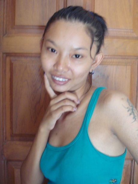 Skinny Asian babe Tik unveils her tiny tits and her shaved pussy