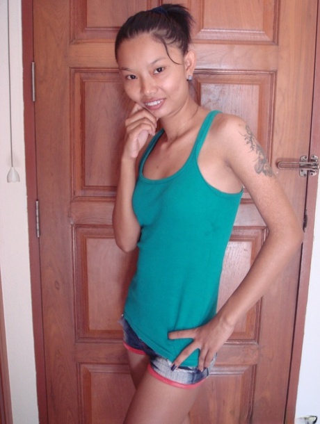 Skinny Asian babe Tik unveils her tiny tits and her shaved pussy