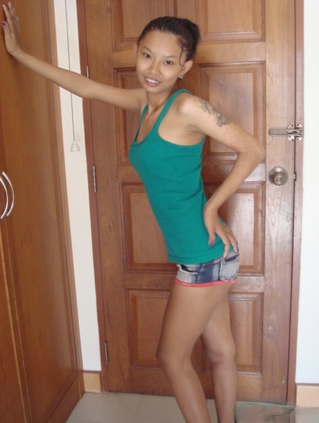 Skinny Asian babe Tik unveils her tiny tits and her shaved pussy