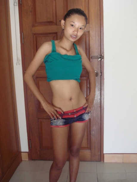 Skinny Asian babe Tik unveils her tiny tits and her shaved pussy