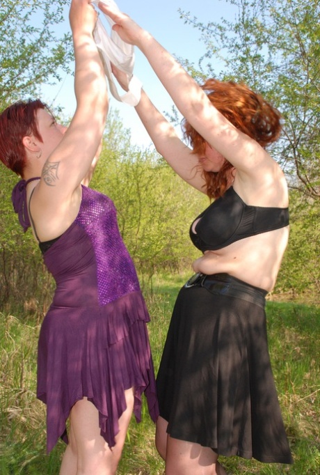Fat redheaded lesbians Jenna K & Monica D rub each other's clits in nature