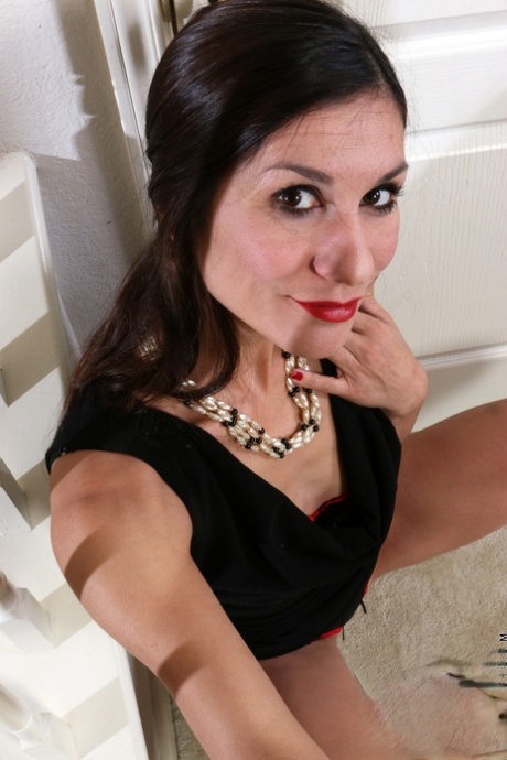 Raven-haired MILF Leah Harris bangs a white toy as she strips down naked